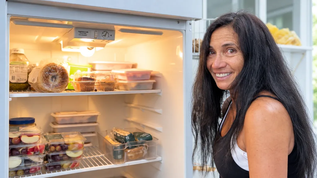 Tevia Herrmann of Tahoe Coalition for the Homeless beside a stocked fridge
